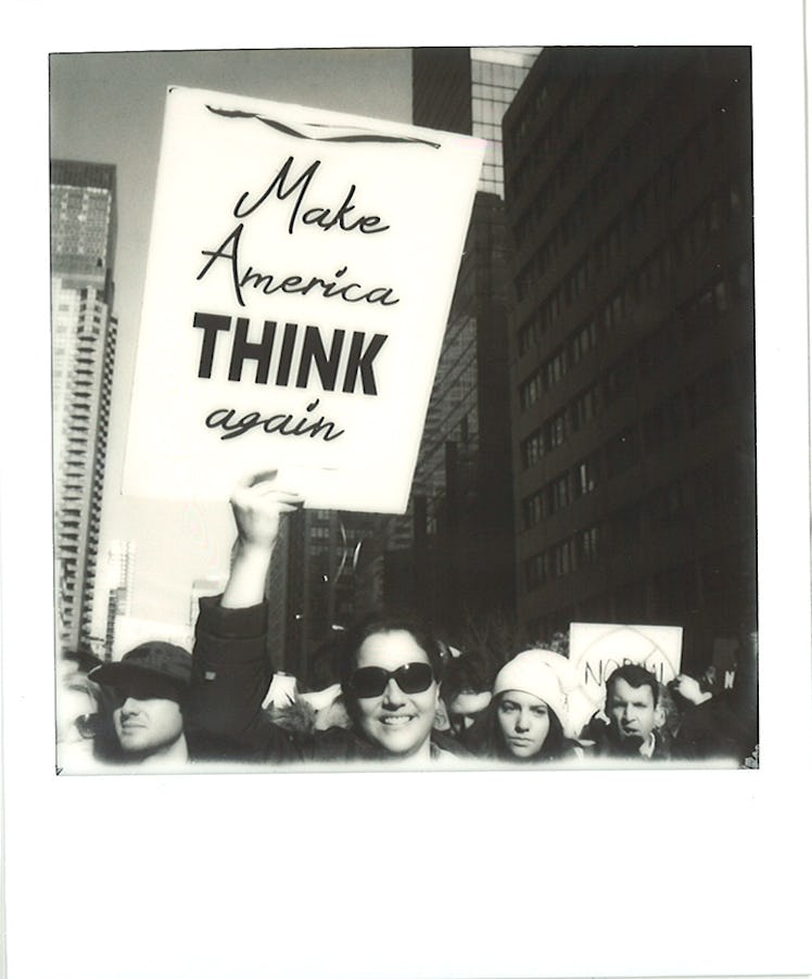 A woman holding a poster with "Make America THINK again" text at the Women’s March in NYC
