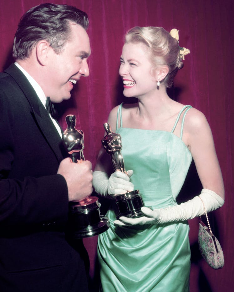 Grace Kelly accepting an Oscar in a light green dress and white gloves 