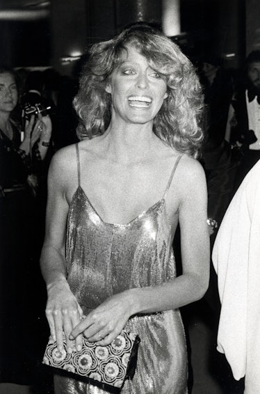 Farrah Fawcett in a shimmery dress with straps and wavy hair at the Oscars 