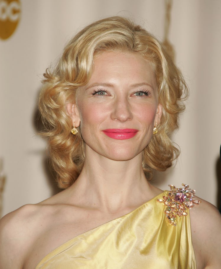 Cate Blanchett in a yellow dress, sporting wavy hair and a pink lip at the Oscars 