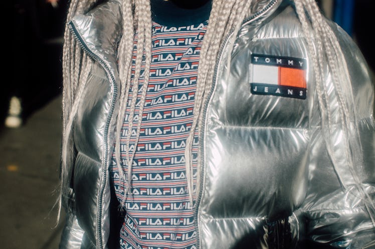 A woman wearing a silver metallic Tommy Jeans puffer jacket and a Fila shirt at Hood by Air