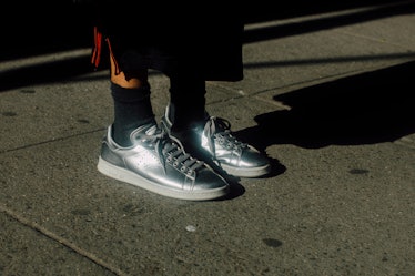 A close-up of a person's silver metallic sneakers and black socks at Hood by Air