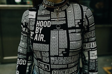 A close-up of a woman wearing a white-on-black text print turtleneck