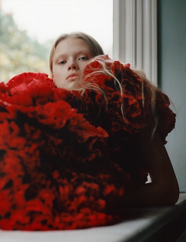 Larissa Hofmann sitting and posing in a red tulle dress