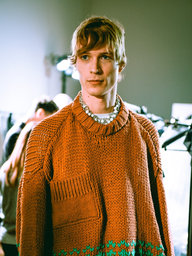 A model wearing an orange sweater for Raf Simons’ Fall 2017 Show