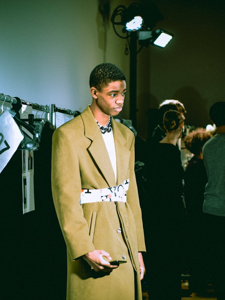 A model wearing a beige coat from Raf Simons' Fall 2017 collection