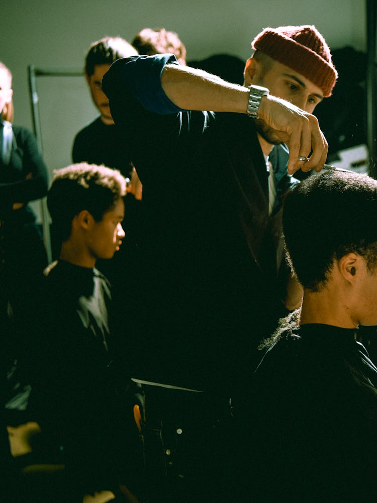 Models getting their hair styled backstage before the presentation of Raf Simons A/W ’17 Collection