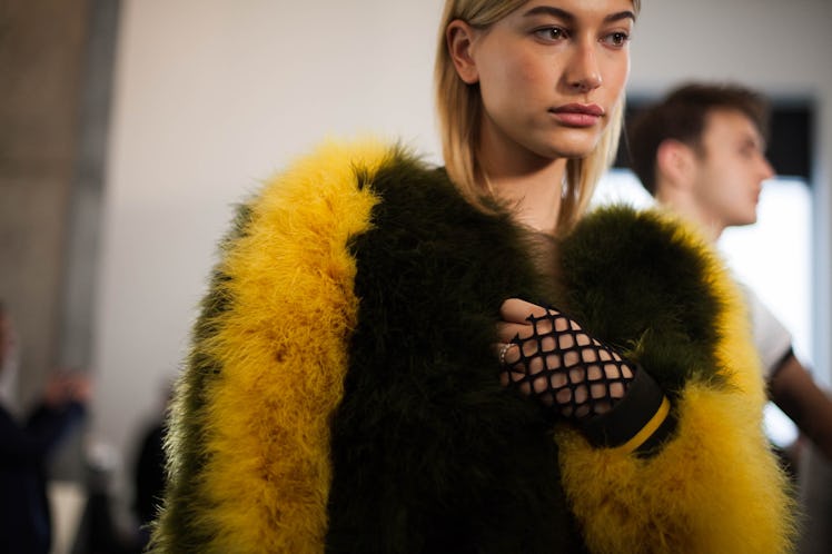 Hailey Baldwin backstage at Zadig & Voltaire Fall 2017 show wearing a black and yellow fur jacket