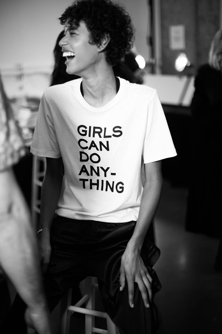 A model laughing in a "girls can do anything" shirt backstage at the Zadig & Voltaire show 