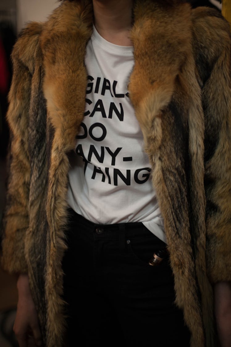 A model in a "girls can do anything" white shirt and a brown fur coat