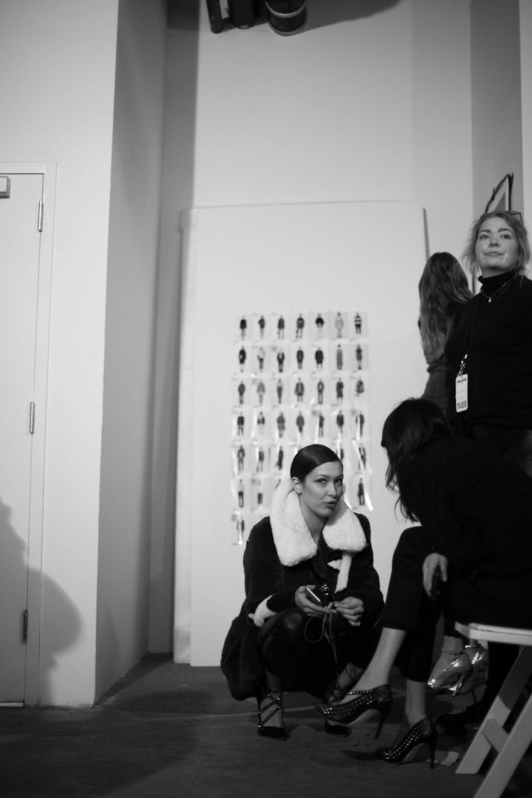 Bella Hadid crouching on the floor while she's explaining something to another model at the Zadig & ...