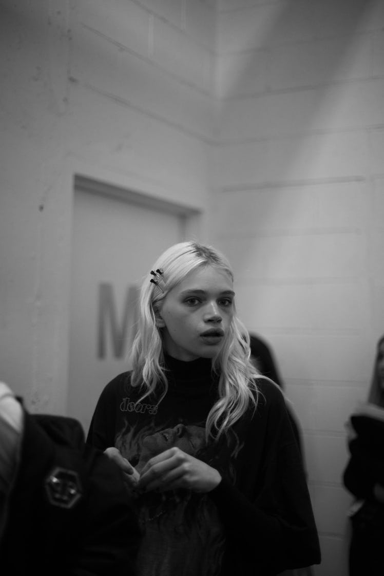 Black and white photo of Daphne Groeneveld backstage at the show looking into the distance 