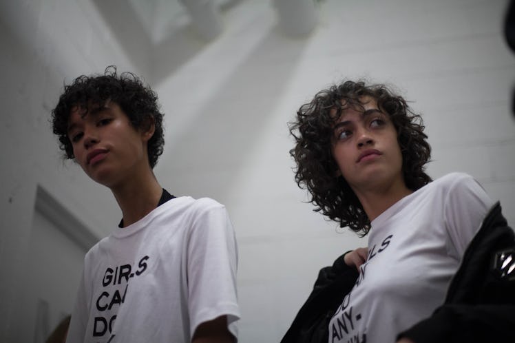 A male and female model in "girls can do anything" shirts backstage at the Zadig & Voltaire Fall 201...