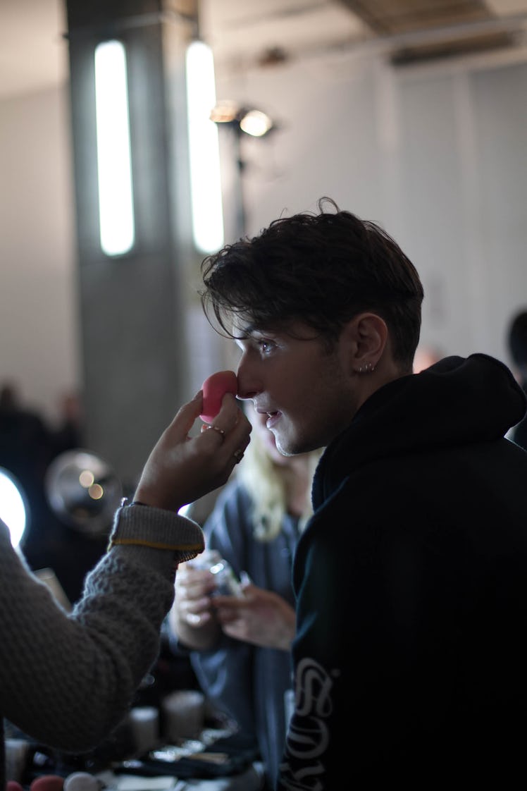 A model getting his makeup touched up backstage at the Zadig & Voltaire Fall 2017 show 