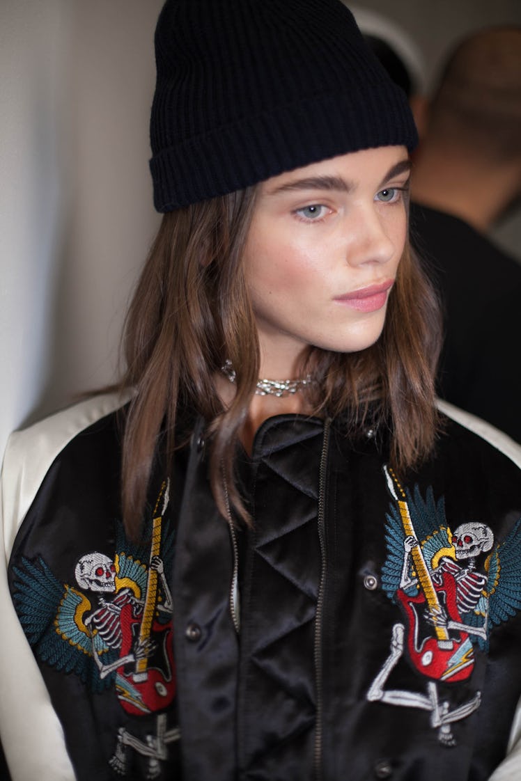 A model backstage at the Zadig & Voltaire 2017 Fall show in a black beanie and a white and black bom...