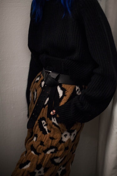 A closeup of a model in a black fleece jacket and a pair of brown fleece pants 