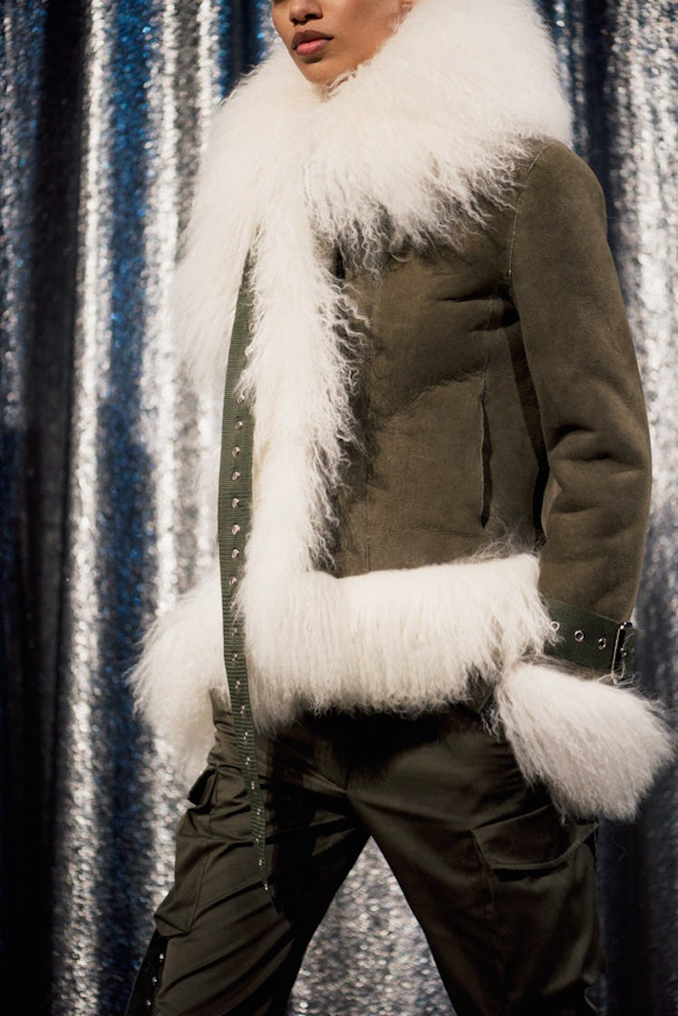 A model in a brown jacket with white fur collar backstage at Monse Fall 2017