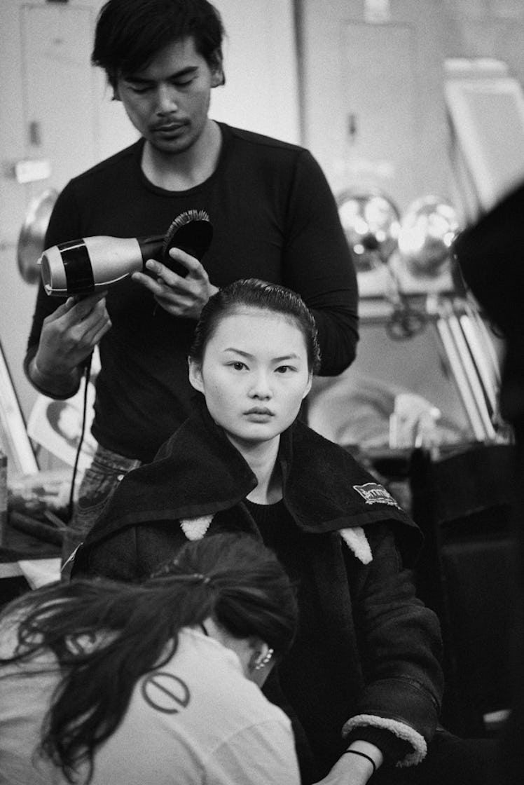 A model sitting and getting ready by stylists backstage at Oscar de la Renta Fall 2017
