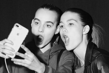 Two models taking a selfie backstage at Oscar de la Renta Fall 2017