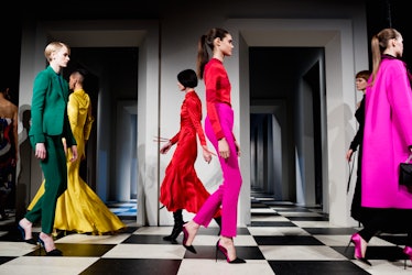 Six models wearing green, yellow, pink and red outfits walking backstage at Monse Fall 2017