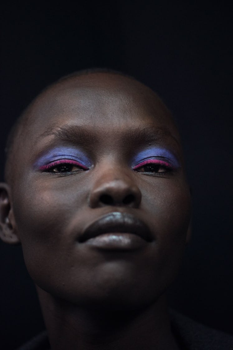 A close-up portrait of a model with blue-pink eyeshadow backstage at Oscar de la Renta Fall 2017