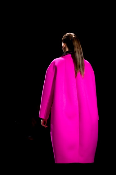 The back of a model in a pink coat walking backstage at Oscar de la Renta Fall 2017