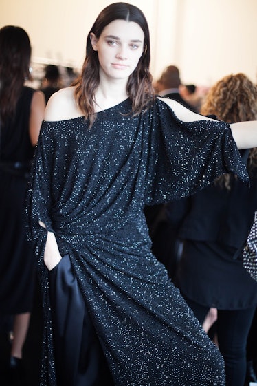 A brunette model posing in a black gown
