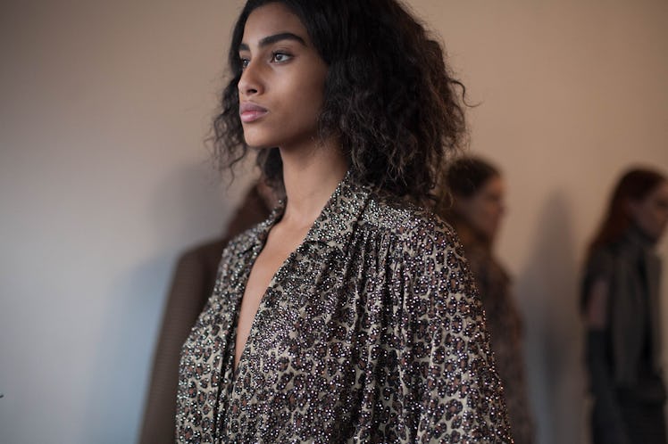 A female model walking while wearing a black and white cardigan