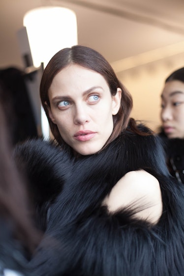 A brunette woman wearing a black fur jacket