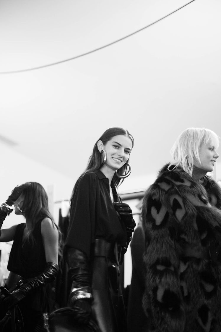 Three models in black outfits standing next to each other