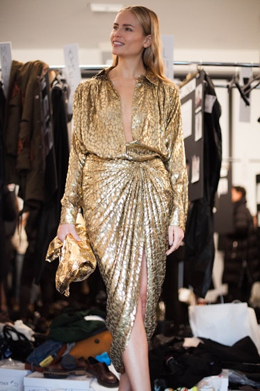A blonde female model posing in golden dress