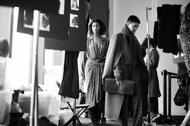 A male and a female model getting prepared for a photo session in a studio