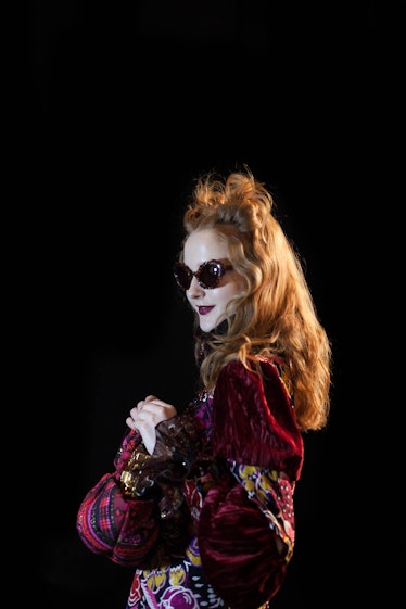 A model in a velvet multi-colored top, black sunglasses and a double knot backstage at Anna Sui Fall...
