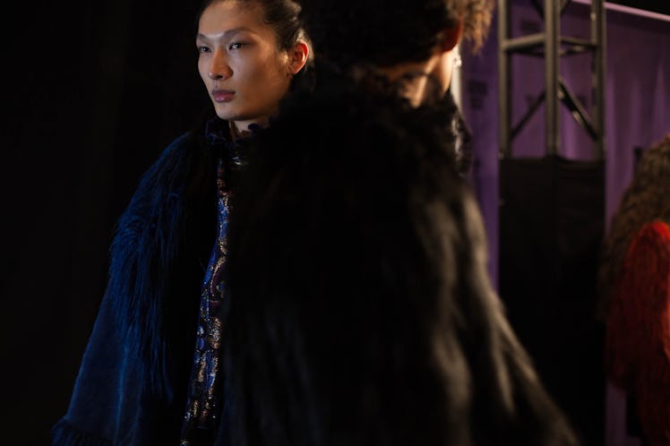 Two models in black coats standing posing backstage at Anna Sui Fall 2017