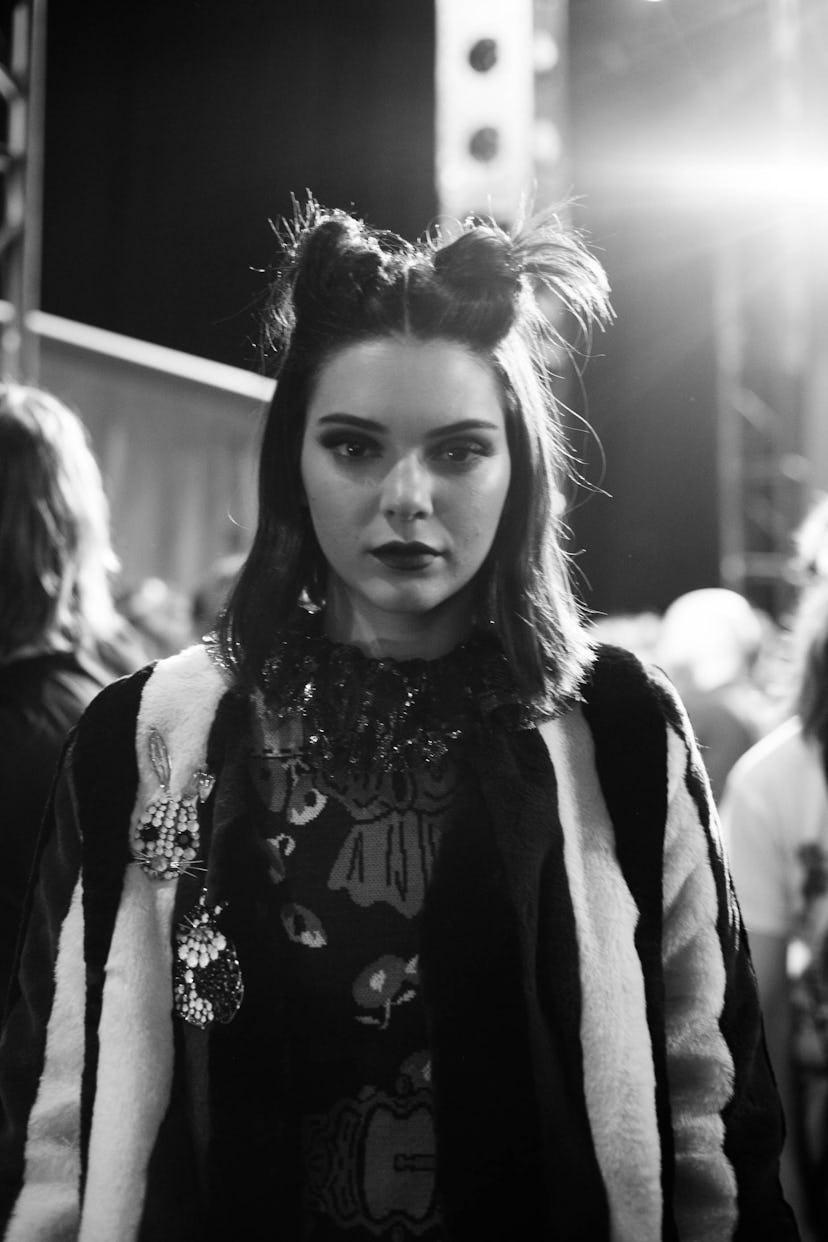 Kendall Jenner in a coat with embroidery with a double top knot at a fashion show