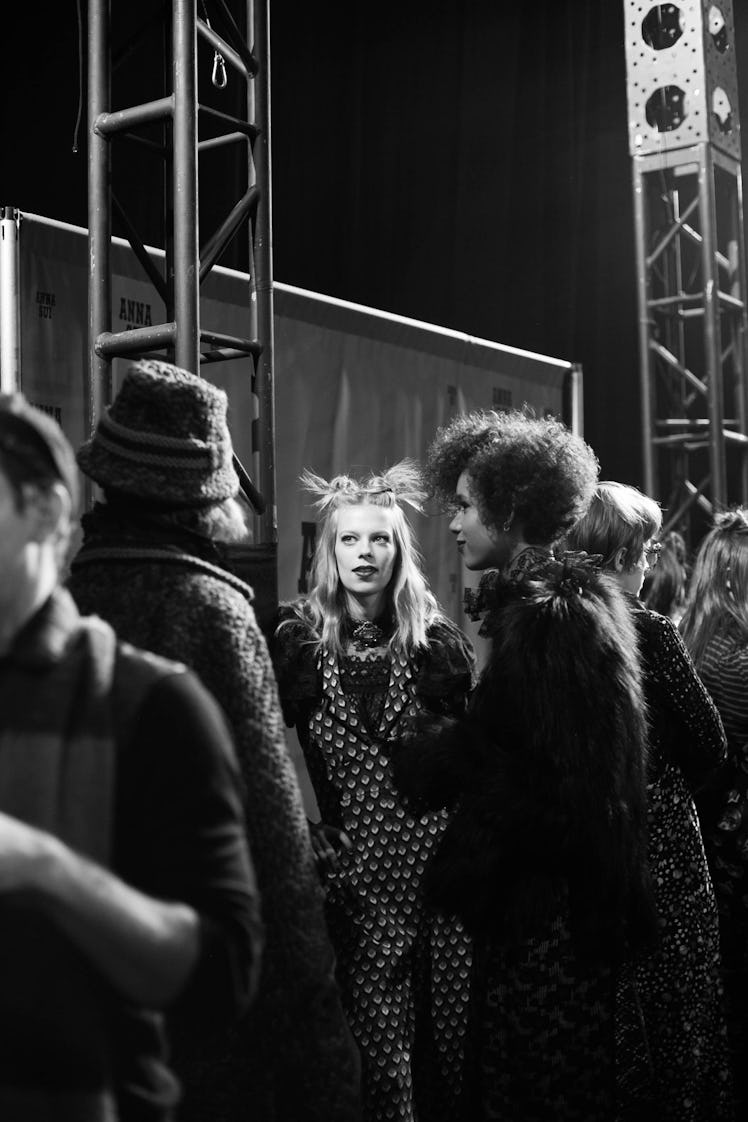 A group of models standing and talking backstage at Anna Sui Fall 2017 in black and white