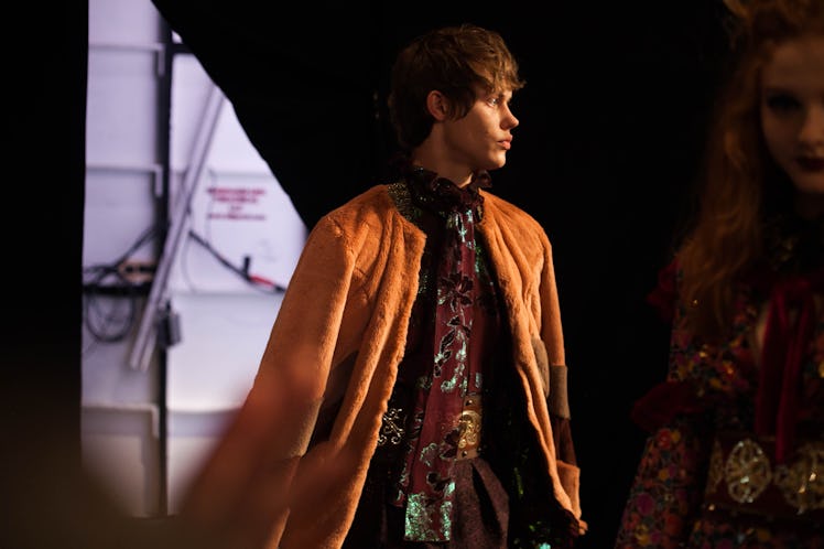 A model in a brown floral top and a beige coat backstage at Anna Sui Fall 2017