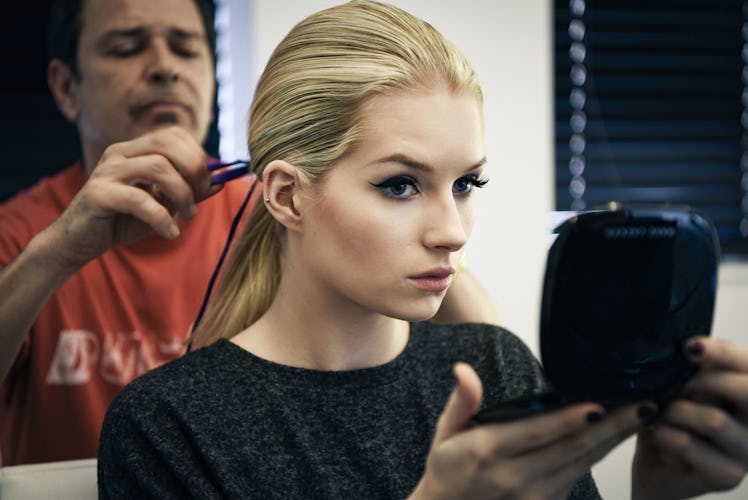Lottie Moss checking her hairstyle while looking at the mirror