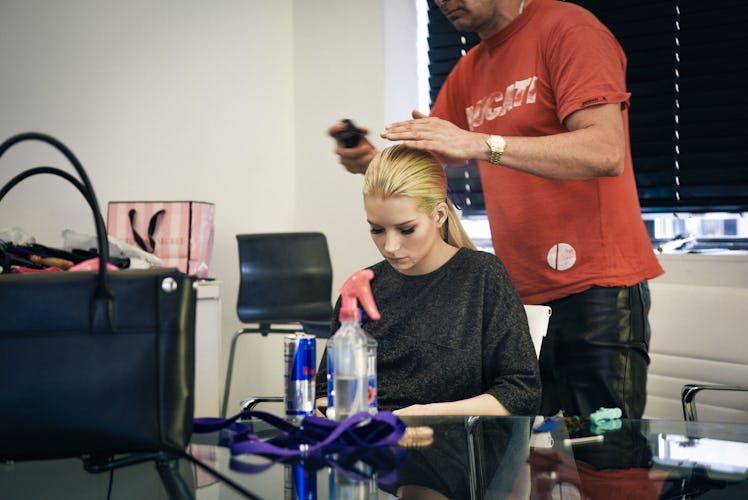 A hairdresser standing above Lottie Moss during his hair treatment
