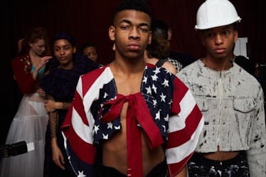 A male model wearing a female American flag inspired blazer and an another male model wearing a whit...