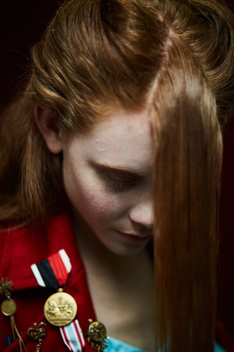 A female model wearing a red blazer with medals on it