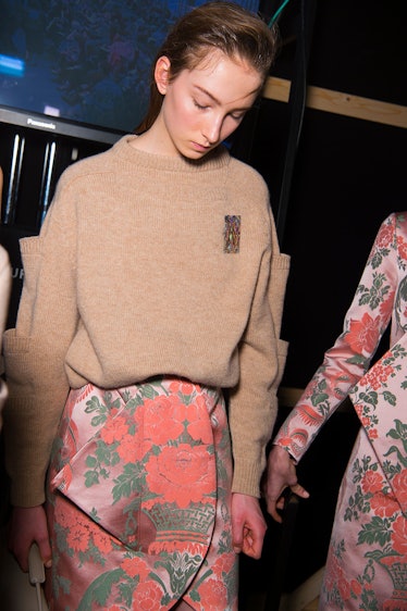 A model in a beige sweater and orange floral skirt at the Christopher Kane Fall 2017 show