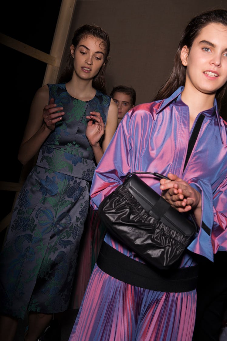 A model in a blue floral dress and a model in a pink dress with a black purse at the Christopher Kan...