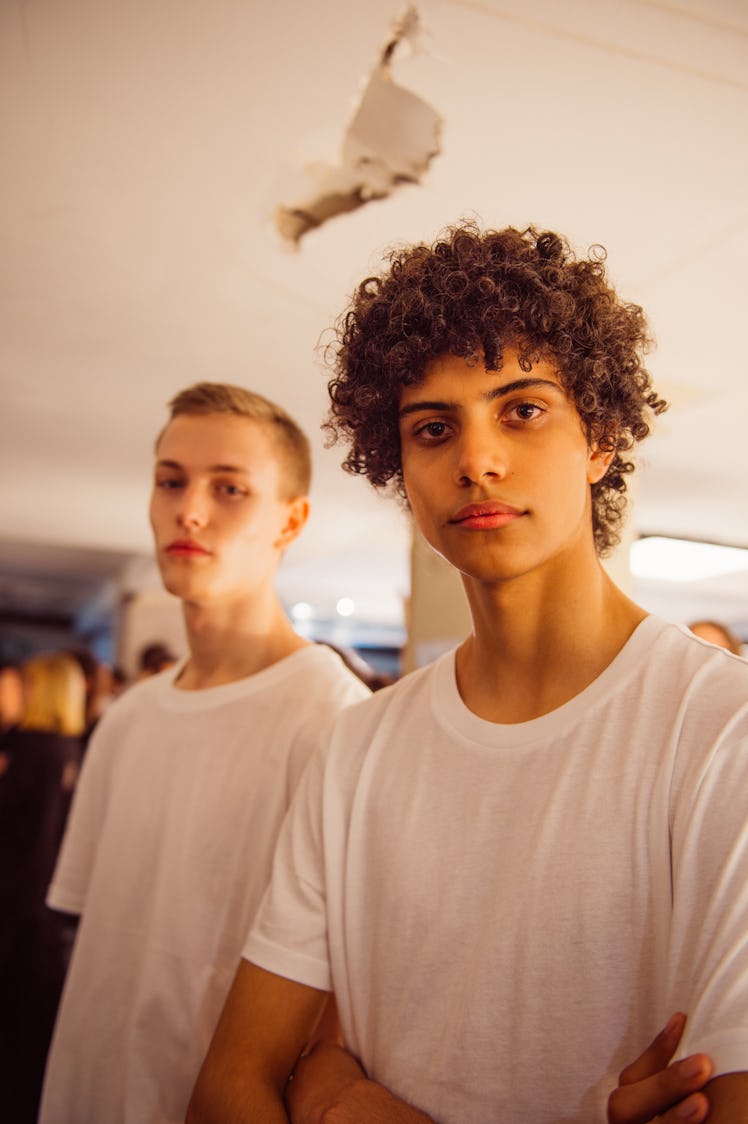 Two male models posing in white shirts at the backstage at Burberry Fall 2017 show