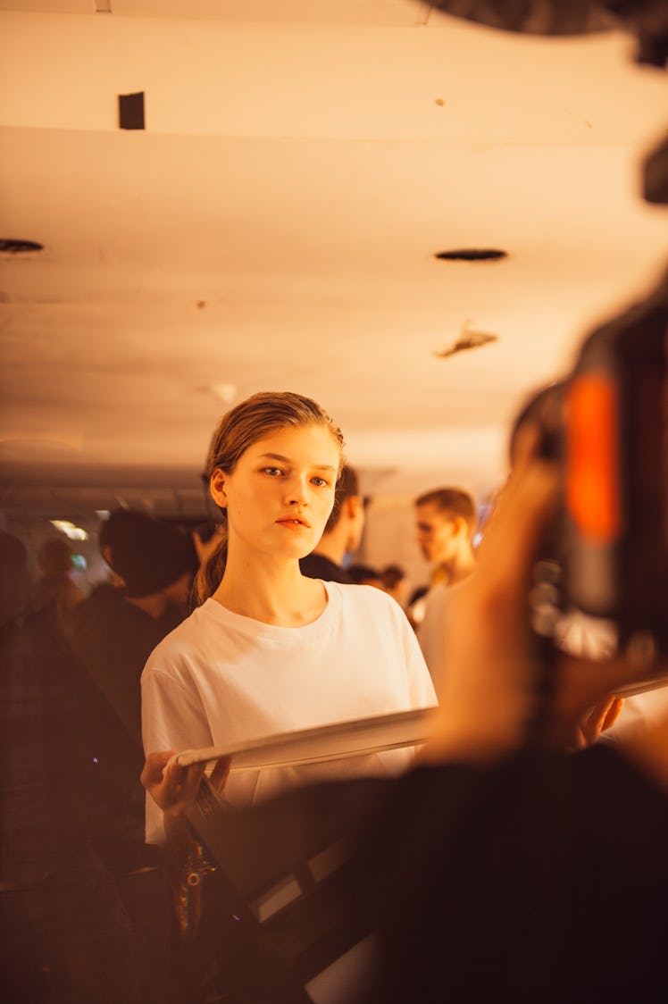 A female model wearing a white shirt at the backstage at Burberry Fall 2017 show