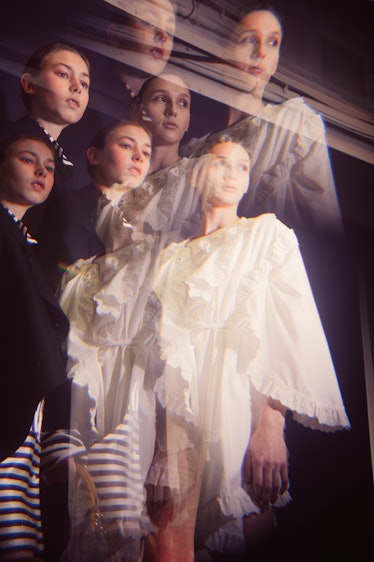Blurred three female models posing in white and black outfits at the backstage at Burberry Fall 2017...