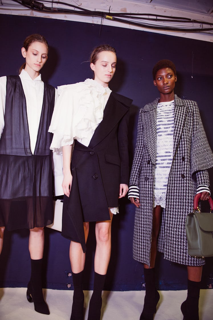 Three female models posing in black and white outfits