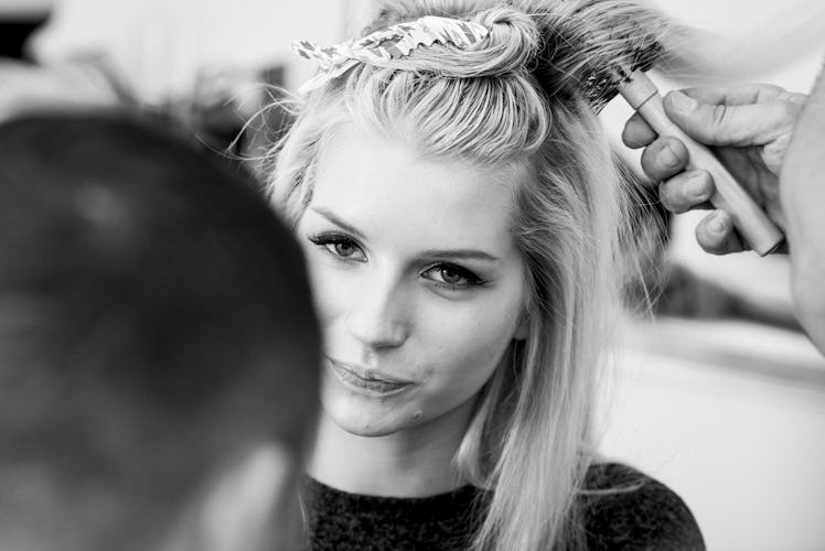 Hairdresser preparing the hairstyle of Lottie Moss