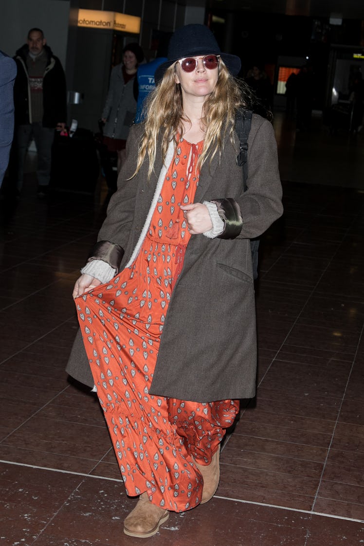 Drew Barrymore wearing a red jumpsuit and a grey coat 