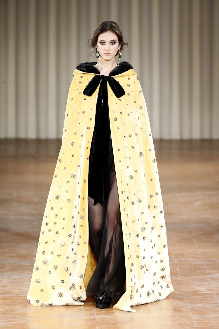 A female model posing in a yellow and black Alberta Ferretti gown